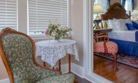 This guest room has a living room one step down from the bedroom, both in a red and blue motif