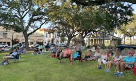 People sitting on their lawn chairs and blankets