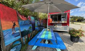 Picnic tables with beach artwork surrounding the area