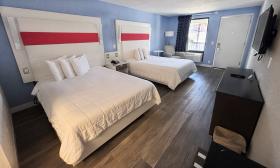 Two-bedroom hotel room with a white and blue decor