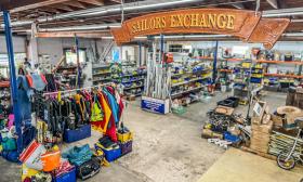 The interior of Sailor's Exchange showing a large carved wooden sign, and things for sale