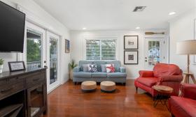 Family lounge in a vacation rental on the beach has a blue and red decor and a lot of seating