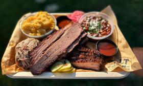 A tray of meats, mac 'n' cheese, and baked beans