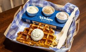 A classic waffle served with a whipped cream flight