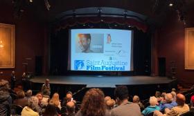 Seen from the back of the audience, looking toward the stage prior to the start of a film about Sydney Poitier