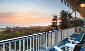 A view of the beach and boardwalk from an upper blue and white deck