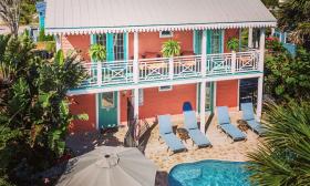 This coral-painted cottage with tourquise trim has a pool