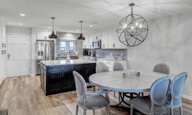 This vacation rental property has an open kitchen and dining room with a round table that seats six