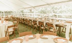 Tables and chairs placed under a white tent