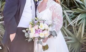 The focus is on the mix of muted roses in the bride's hand