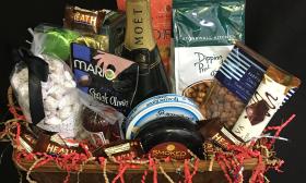 A gift basket with chocolates, savory treats, and a bottle of sparkling wine