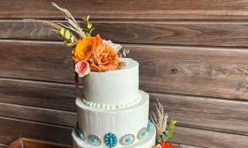 A wedding cake by Choco-lattes, featuring torqouise jewelry and autumn flowers