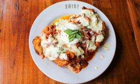 A dish of chicken parmesan topped with garnishes