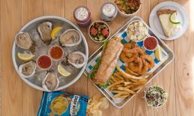 Oysters, shrimp, a sandwich, and other food items