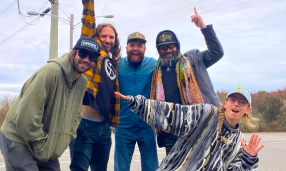 Bandmates from Bearly Dead smile and pose in front of electric poles and telephone lines.