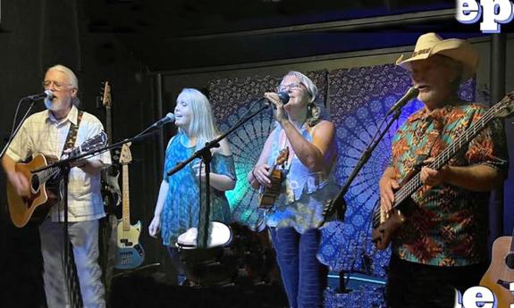 The folk band In Good Company onstage, playing