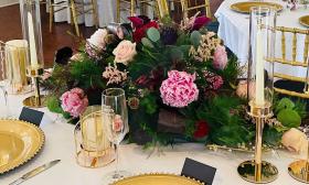 A stunning lush head table bouquet with pink roses and deep green fronds 