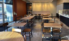 Wooden tables and chairs make up the indoor dining