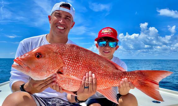 Guests holding a red snapper