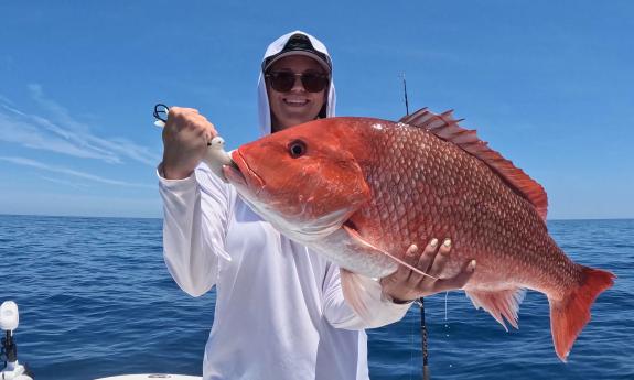 A red snapper held up by a guest