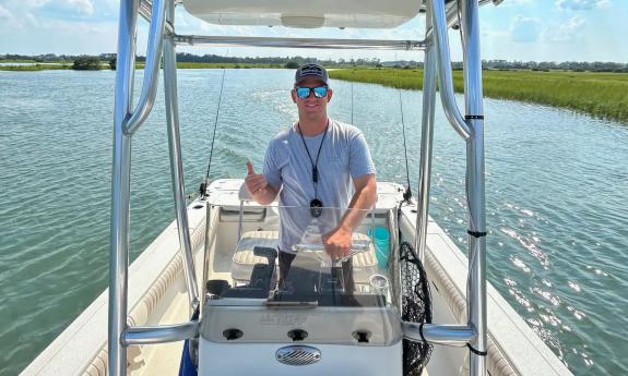 Captain Logan Russom steering his boat