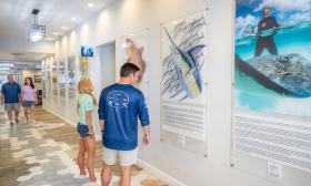 A couple looking at the decorative Guy Harvey signs in the lobby of the St. Augustine Beach resort