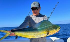 A guest holding up mahi-mahi