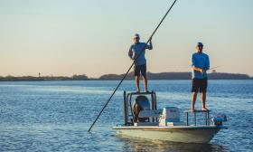 Captain Tommy poling from the platform of the boat