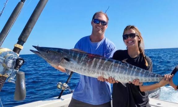 Guests holding a freshly caught fish