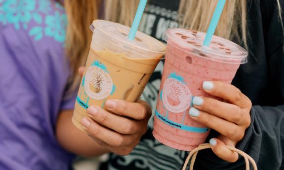 A coffee and smoothie being held