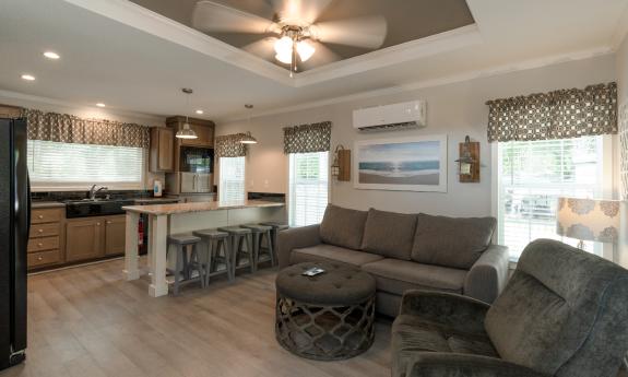 The living and kitchen area of a Park Row stationary rental home in an RV lot