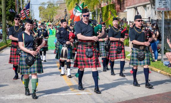 Pipers in red and green plaid at the start of the St. Patrick's Parade