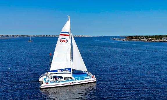 An aerial view of the 65-foot sailing catamaran Fury, with Vilano and the Vilano bridge in the background