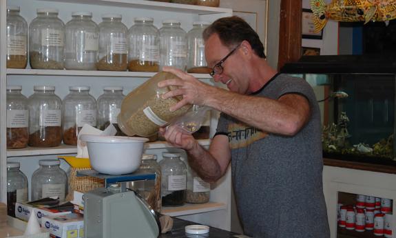 An employee pouring tea products in a funnel