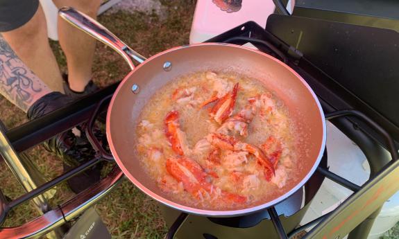 Northern lobster in a hot pan of butter over a gas stove