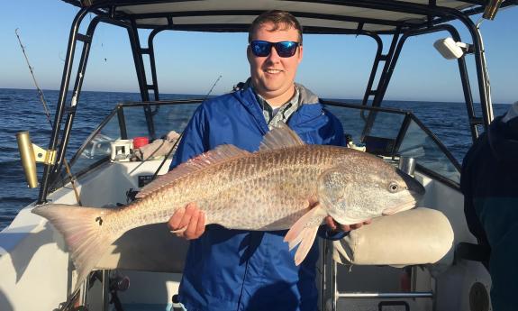 A guest holding a freshly caught fish