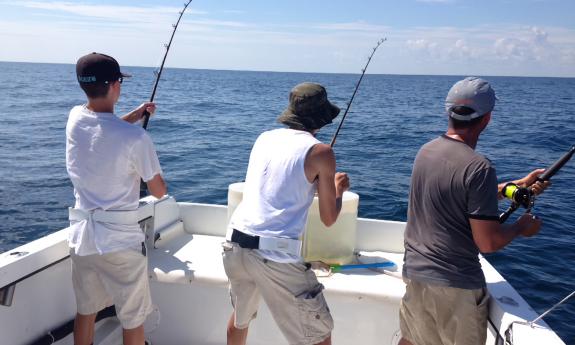 Three guests fishing aboard the MisStress boat