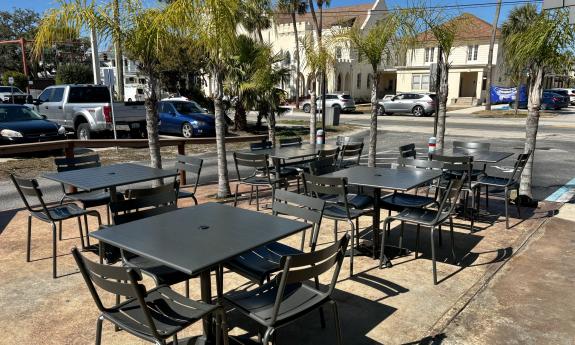 Patio seating with greenery bordering the space