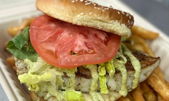 A grouper sandwich on a bed of fries