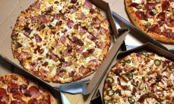 Various pizzas displayed on a table