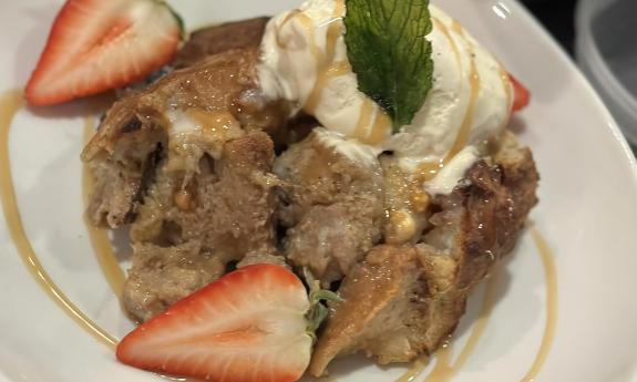 Banana bread pudding topped with strawberries and ice cream 