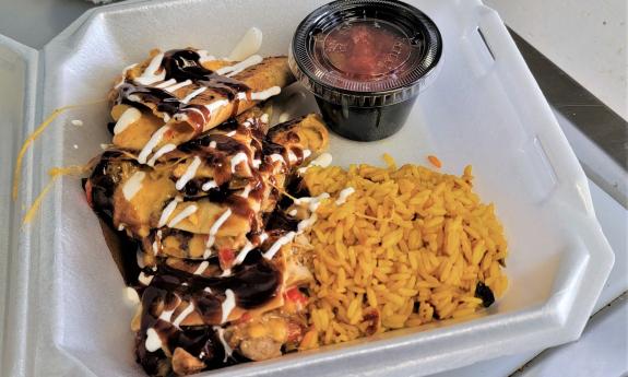A specialty quesadilla and Spanish rice in a to-go box