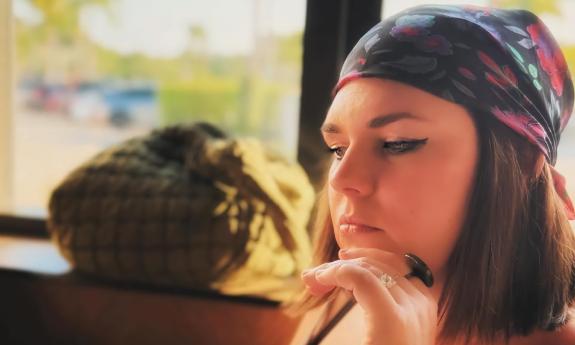 Megan Linville, sitting near a window