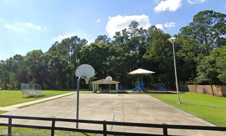 A county park, with basketball court in the foreground and a pavilion at the far end