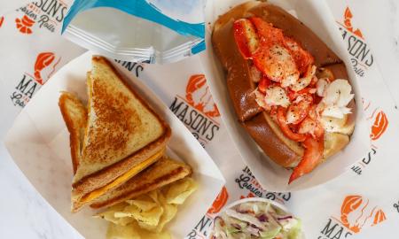 A lobster roll and grilled cheese being served