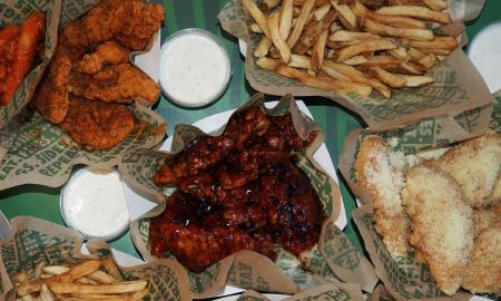 A spread of chicken wings, fries, and dips
