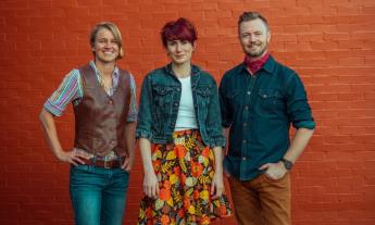 Bandmates from House of Hamill pose in front of an orange brick wall. 