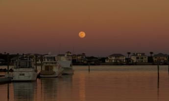 A moon casts orange light over St. Augustine