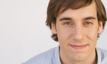 Mike Hanford wears a blue shirt and poses in front of a white backdrop. 