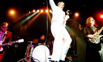 Bandmates from Planet Duran perform on stage.